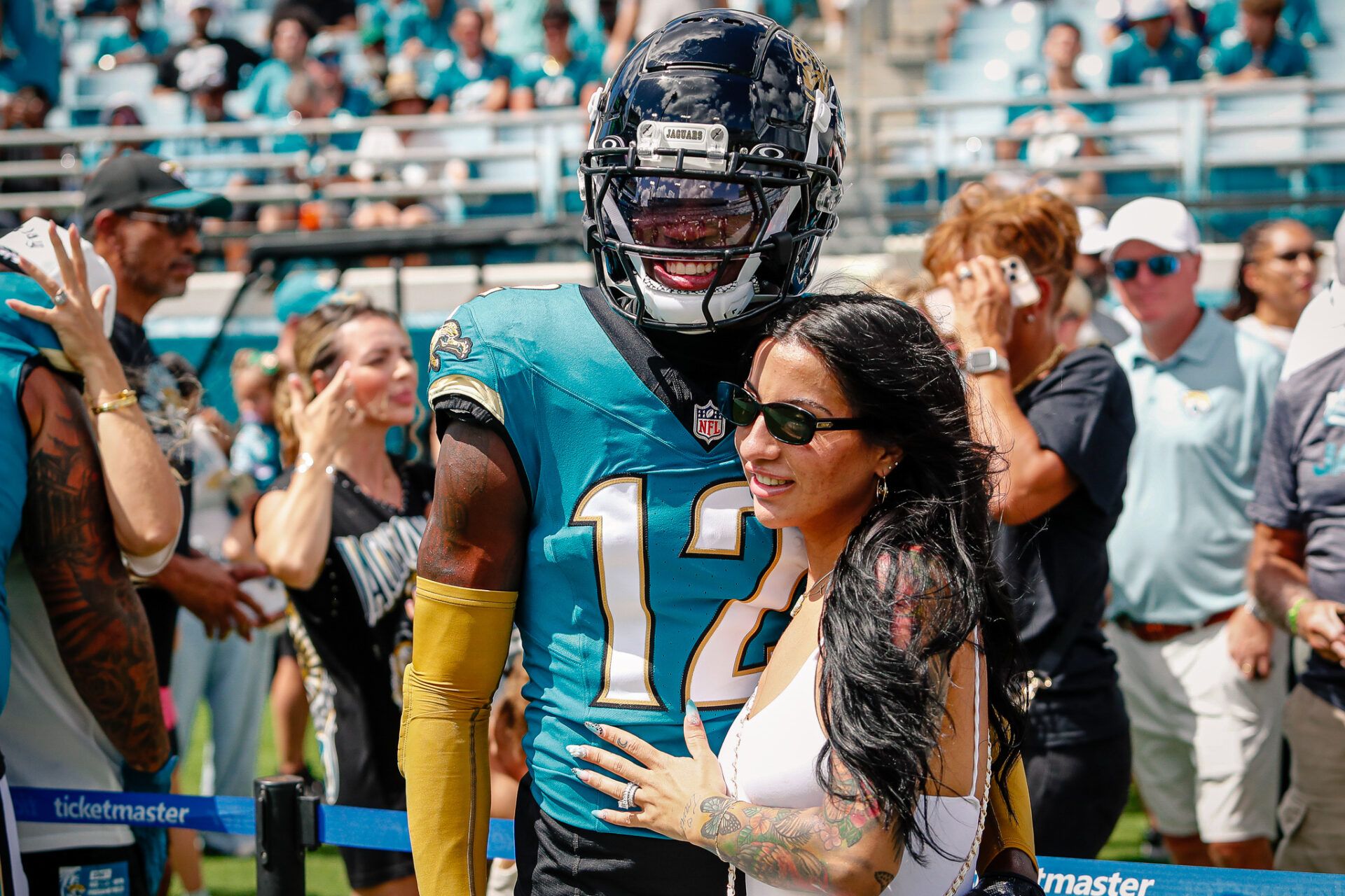 Jacksonville Jaguars player Travis Hunter (12) with his wife during pregame against the Houston Texans at EverBank Stadium.