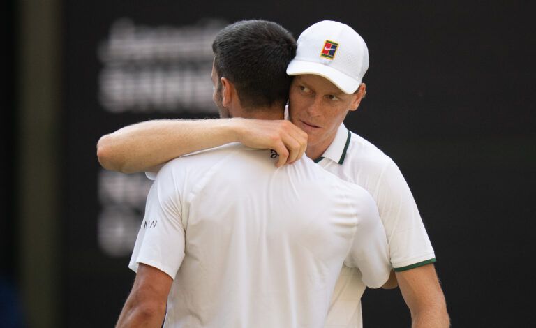 Jannik Sinner of Italy at the net with Novak Djokovic of Serbia after their semifinal match on day 12 at All England Lawn Tennis and Croquet Club.