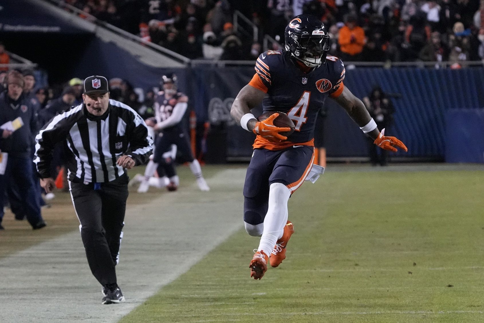 Chicago Bears running back D'Andre Swift (4) runs after the catch against the Green Bay Packers during the second half of an NFC Wild Card Round game at Soldier Field.