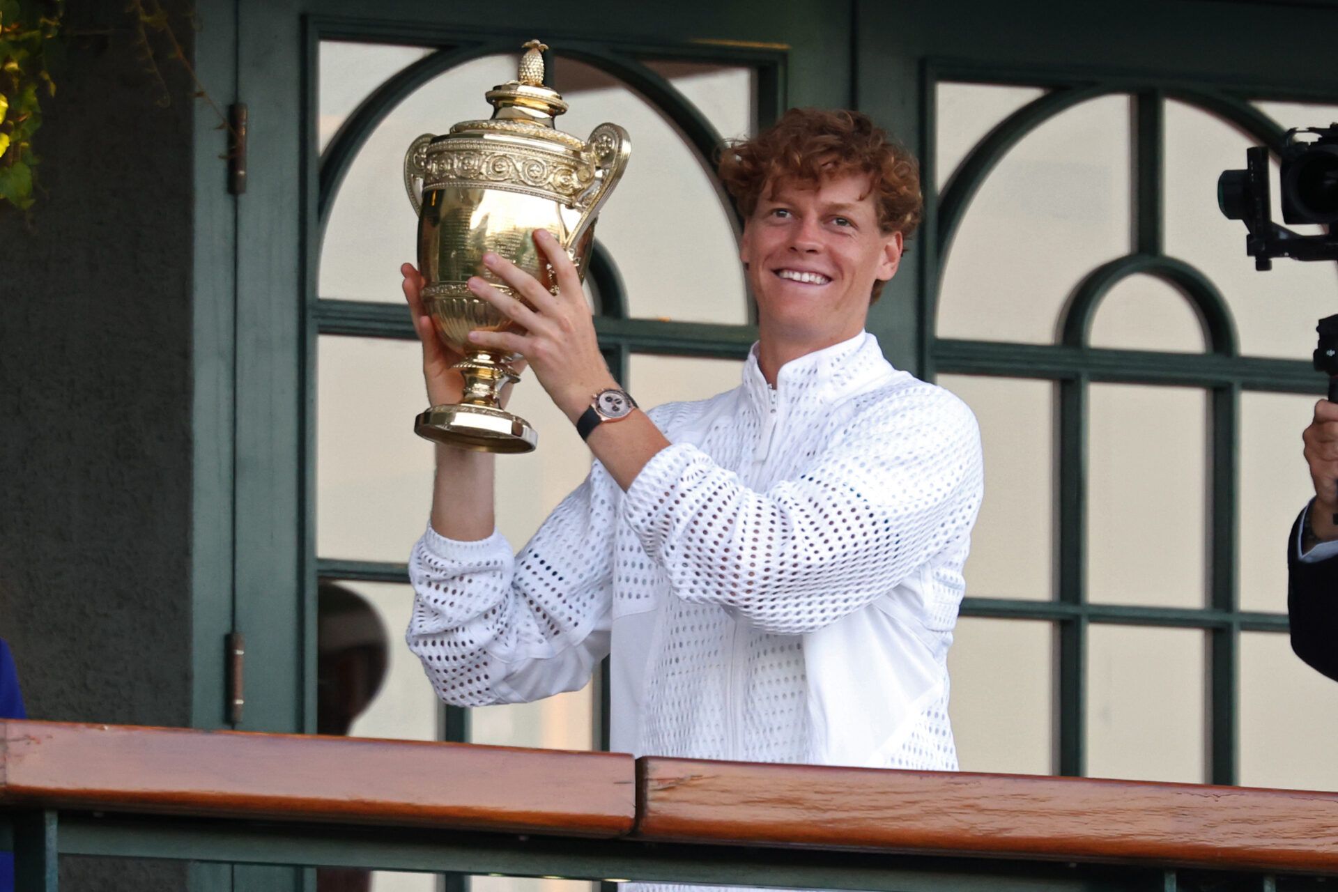Jannik Sinner (ITA) holds the gentlemen's singles championship trophy on the South West Hall Balcony of Centre Court after the gentlemen's singles final of The Championships Wimbledon 2026 at All England Lawn Tennis and Croquet Club.
