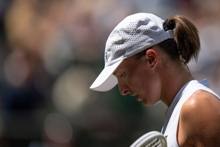 Iga Swiatek of Poland returns a shot during her match against Alexandra Eala of the Philippines on day six at All England Lawn Tennis and Croquet Club.