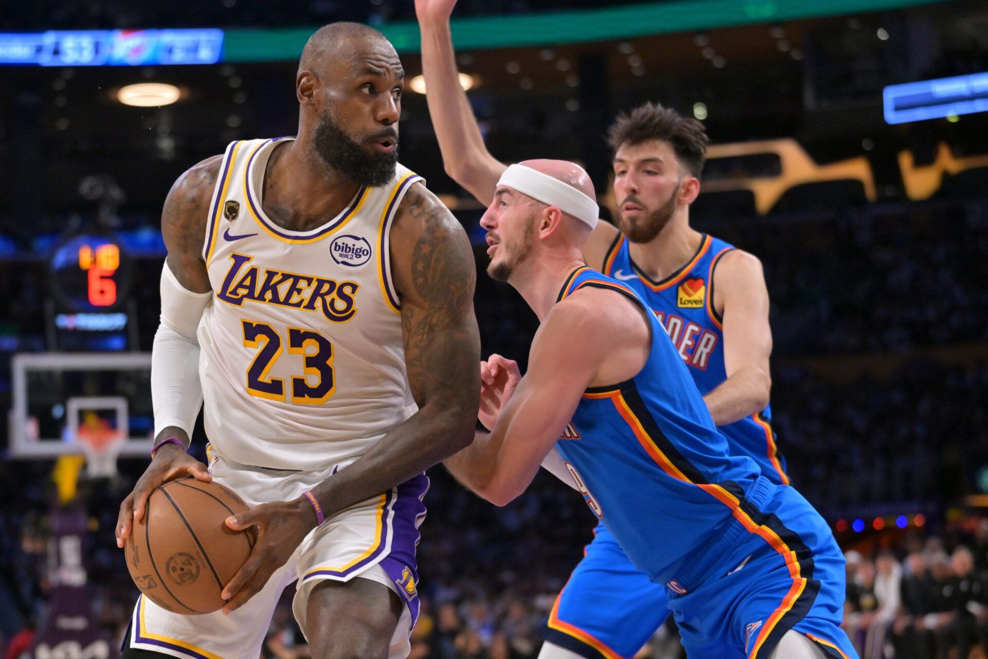 Los Angeles Lakers forward LeBron James (23) is defended by Oklahoma City Thunder guard Alex Caruso (9) and center Chet Holmgren (7) in the first half of game three of the second round of the 2026 NBA Playoffs at Crypto.com Arena.