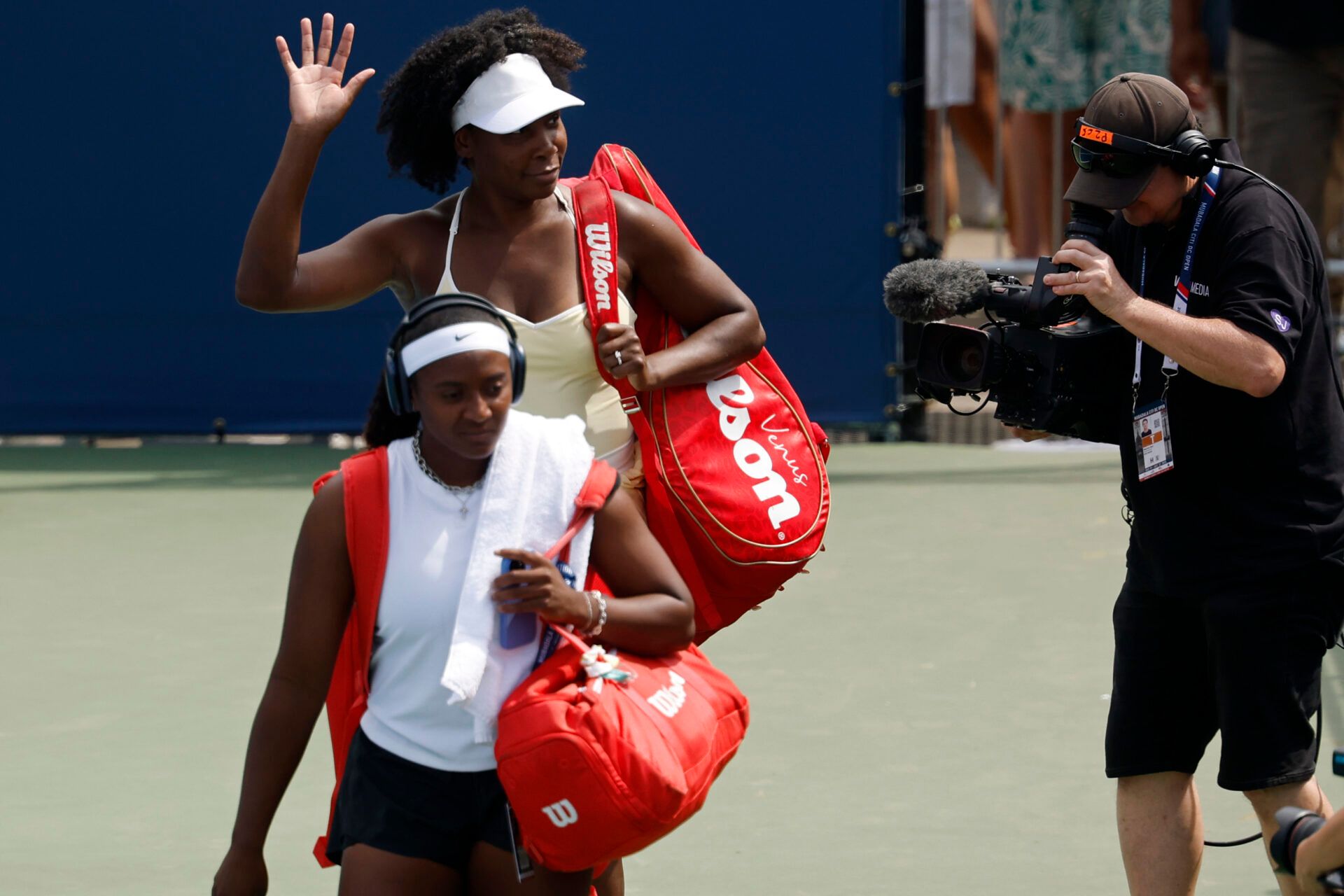 Venus Williams (USA) waves to the crowd while walking onto the court with partner Hailey Baptiste (USA) prior to their women's doubles match against Eugenie Bouchard (CAN) and Clervie Ngounoue (USA) (both not pictured) on day one of the Mubadala Citi DC Open at Rock Creek Park Tennis Center.