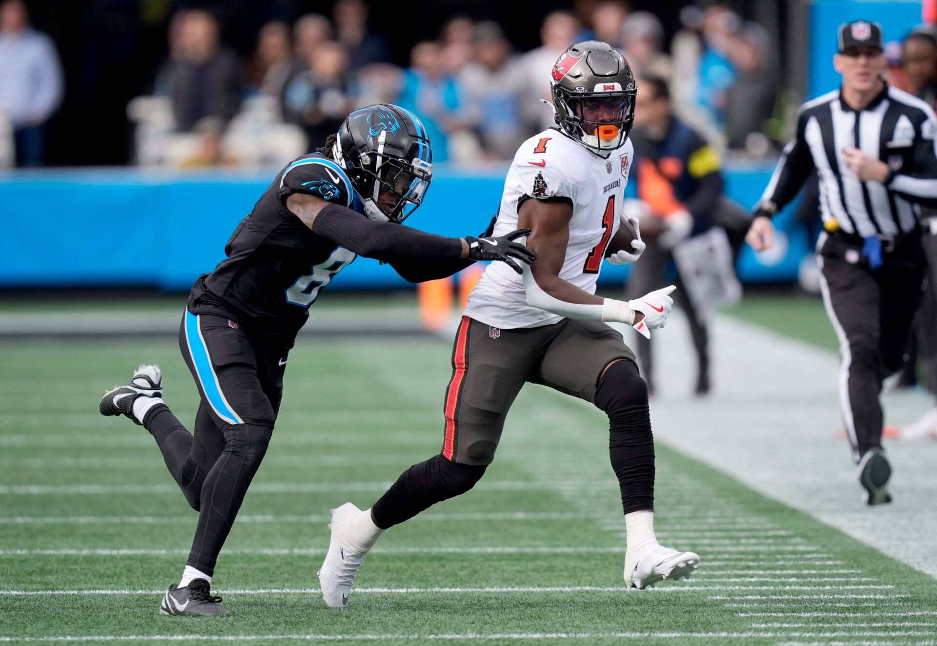 Tampa Bay Buccaneers running back Rachaad White (1) runs against Carolina Panthers cornerback Jaycee Horn (8) during the first half at Bank of America Stadium.