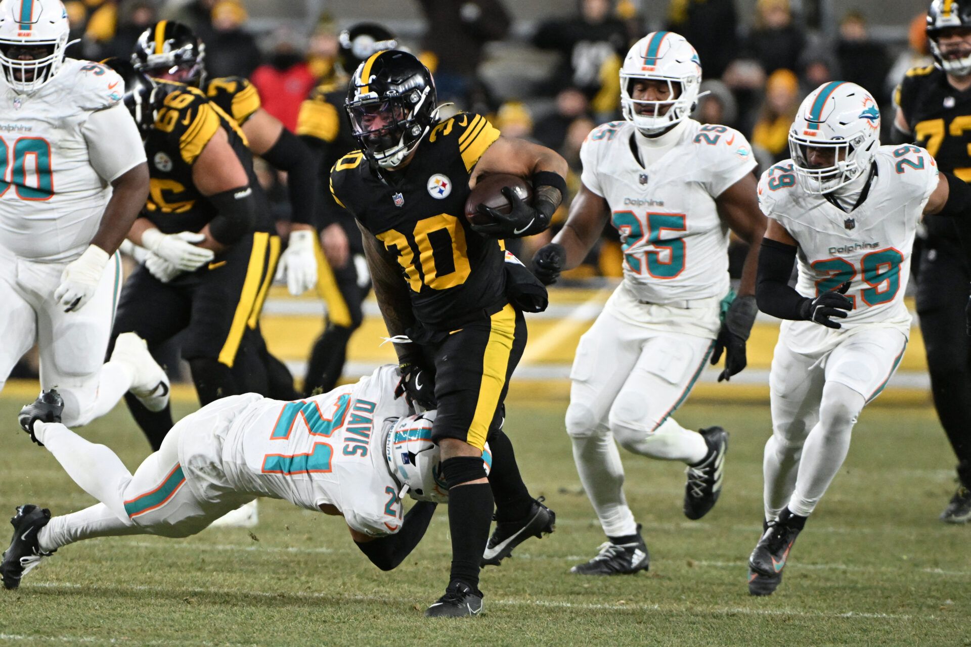 Pittsburgh Steelers running back Jaylen Warren (30) runs the ball while defended by Miami Dolphins safety Ashtyn Davis (21) in the second quarter at Acrisure Stadium.