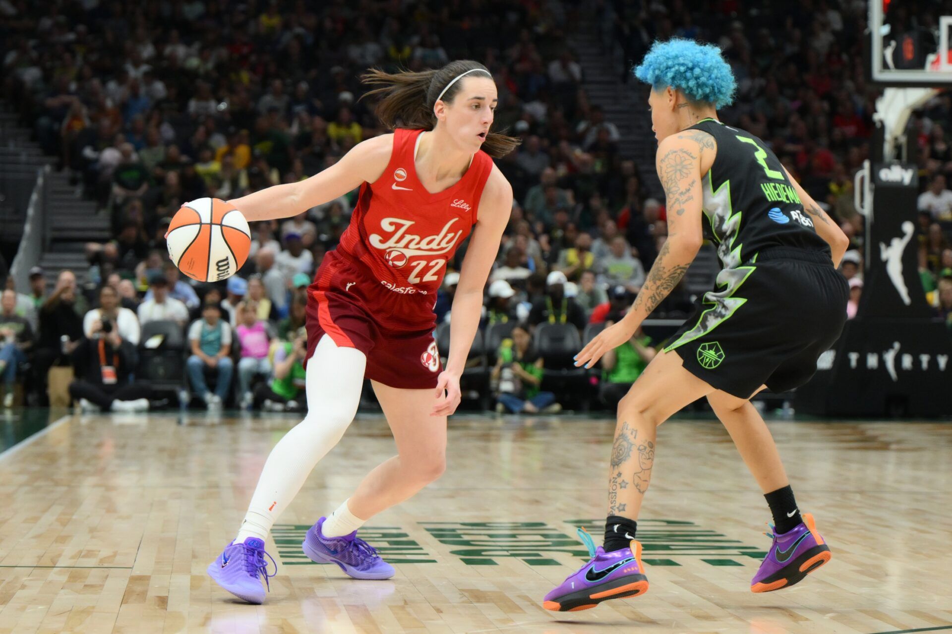 Indiana Fever guard Caitlin Clark (22) dribbles the ball while guarded by Seattle Storm guard Natisha Hiedeman (2) during the the second half at Climate Pledge Arena.