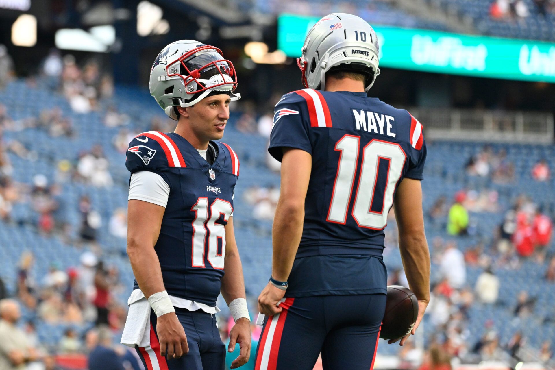 New England Patriots quarterback Tommy DeVito (16) speaks to quarterback Drake Maye (10) before a game against the Indianapolis Colts at Gillette Stadium.