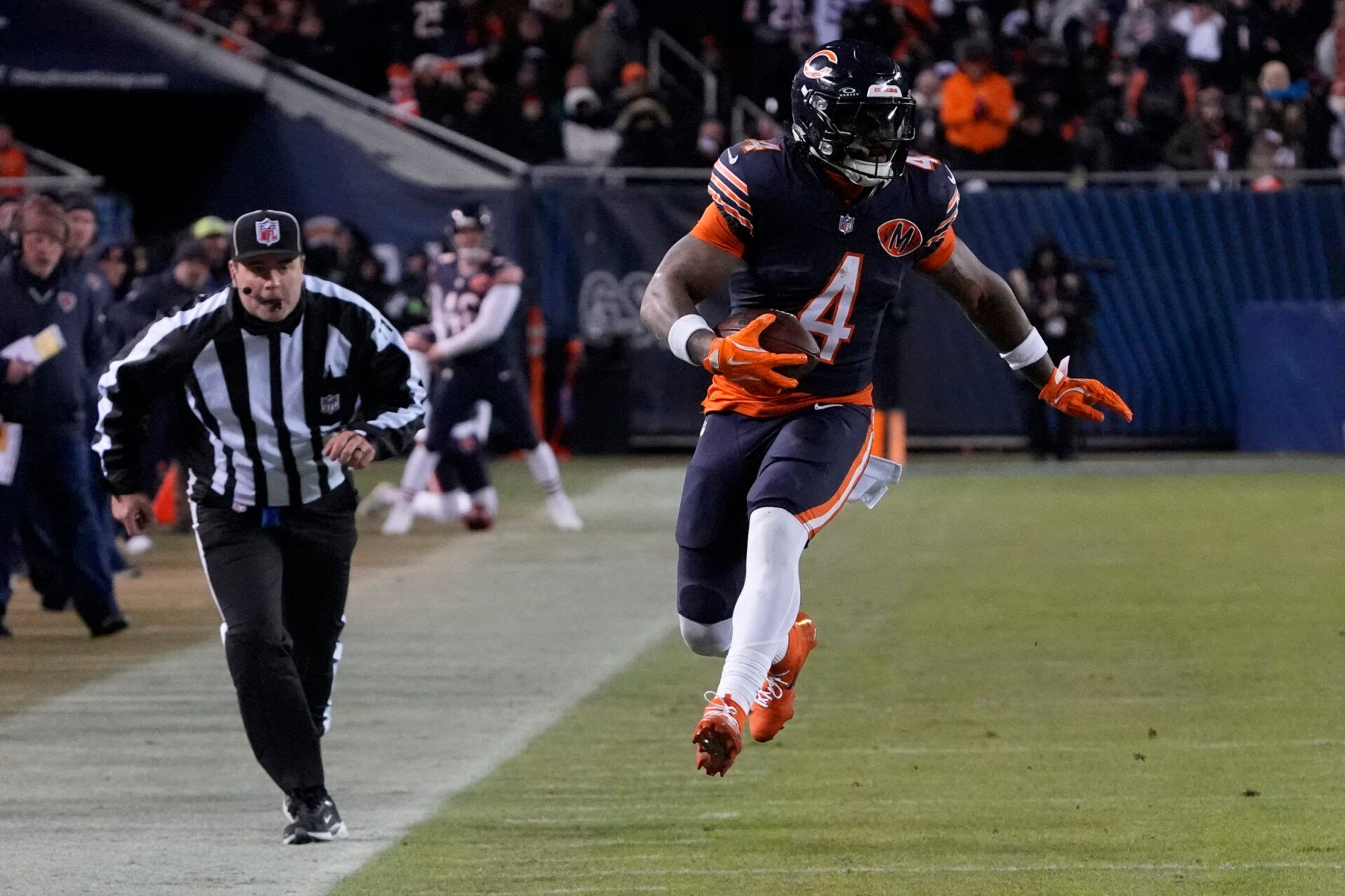 Chicago Bears running back D'Andre Swift (4) runs after the catch against the Green Bay Packers during the second half of an NFC Wild Card Round game at Soldier Field.