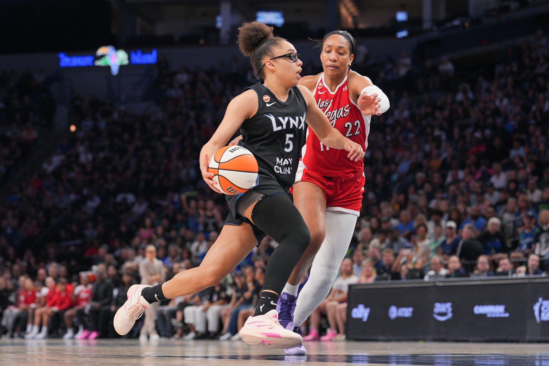 Minnesota Lynx forward Olivia Miles (5) dribbles against the Las Vegas Aces forward A'ja Wilson (22) in the fourth quarter at Target Center.