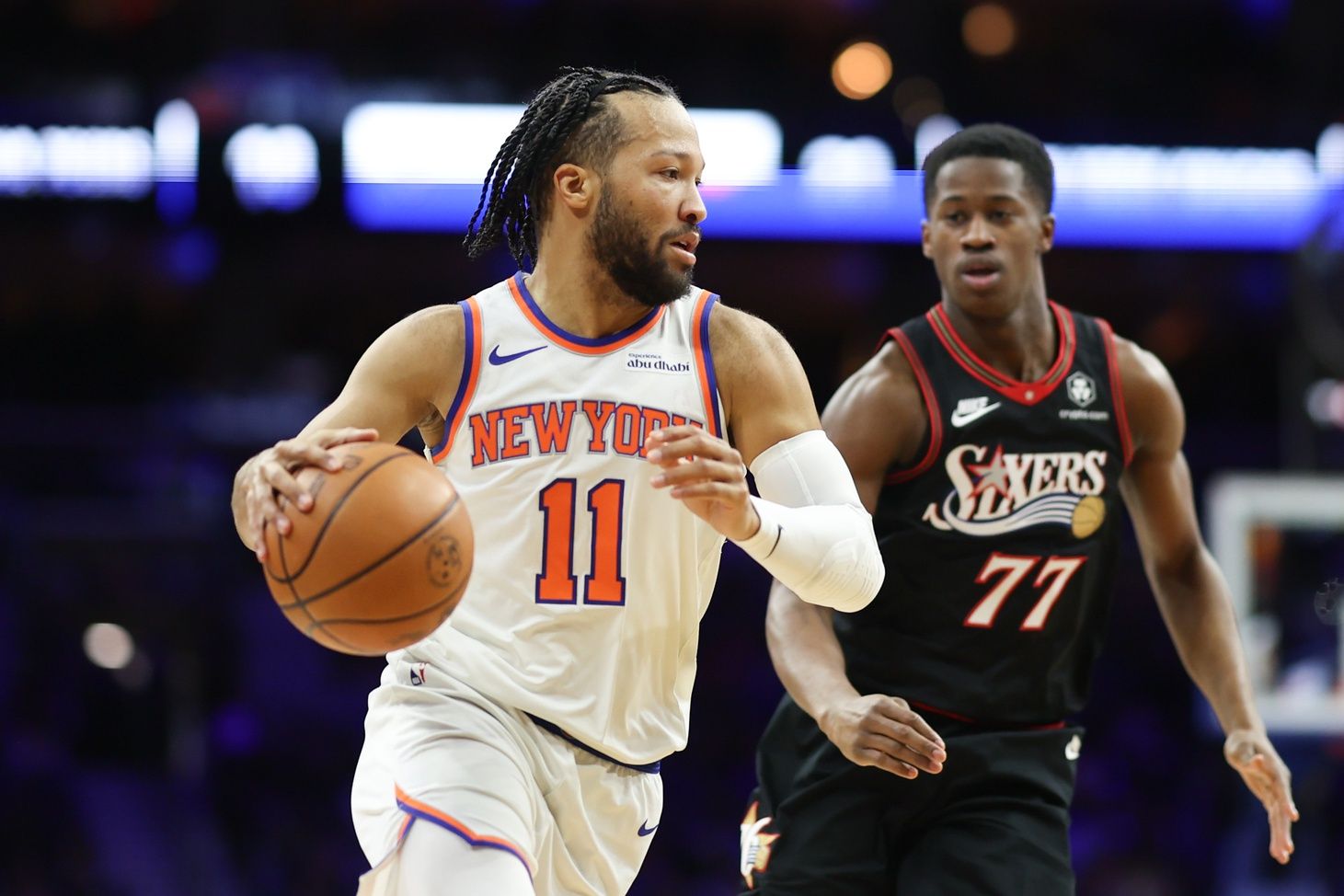 New York Knicks guard Jalen Brunson (11) dribbles the ball in front of Philadelphia 76ers guard Vj Edgecombe (77) during the first quarter at Xfinity Mobile Arena.