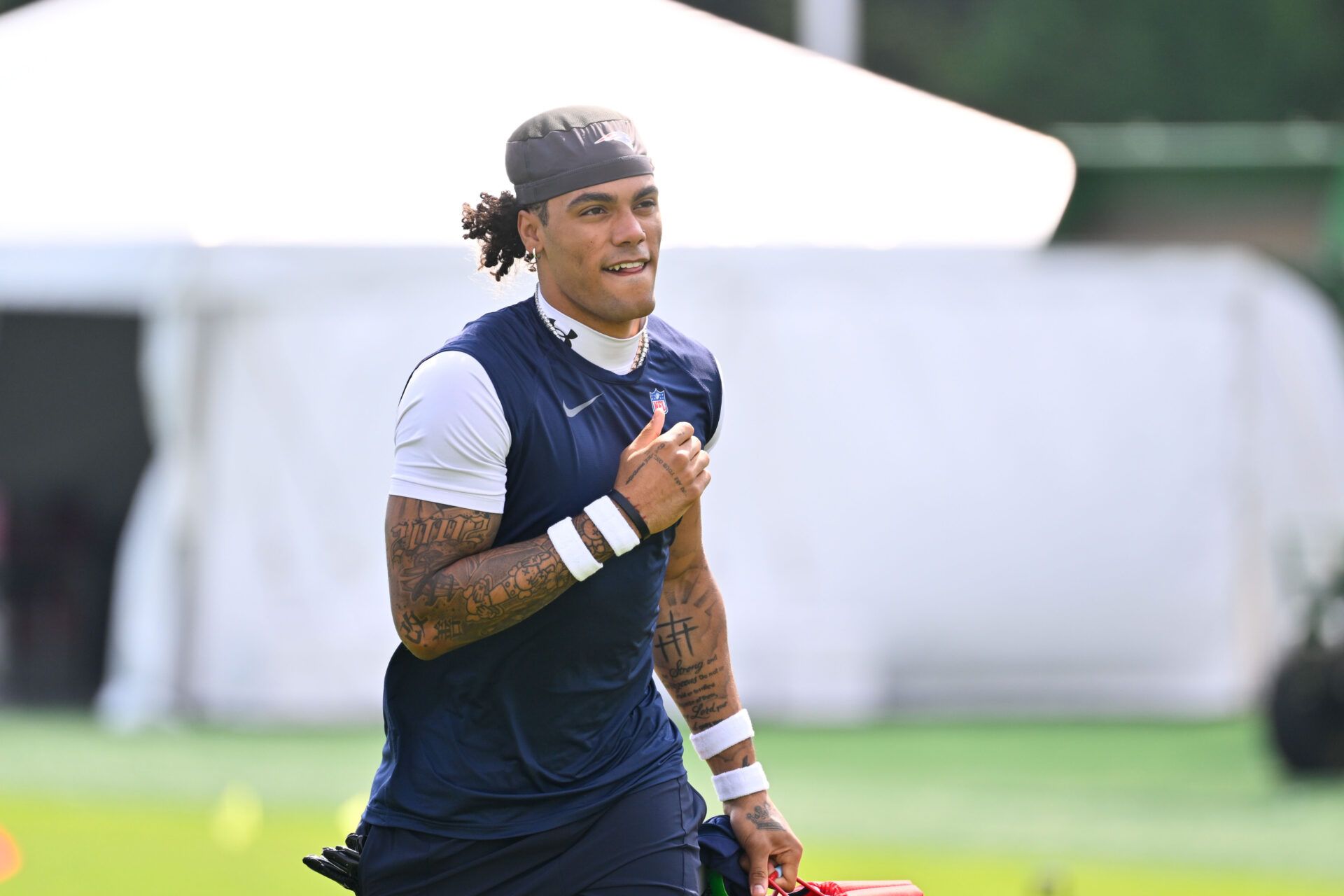 New England Patriots cornerback Christian Gonzalez (0) walks to practice for training camp at Gillette Stadium.
