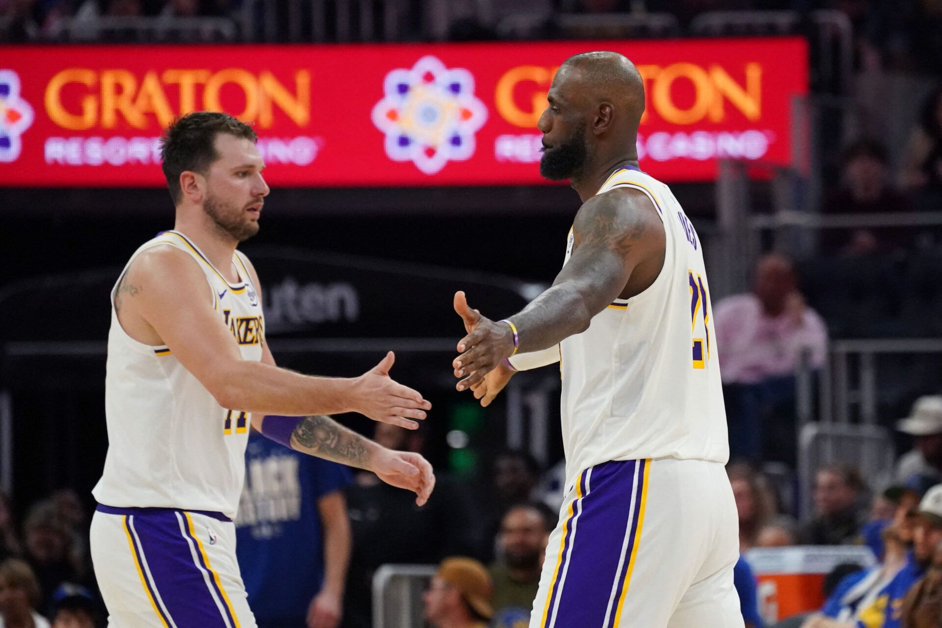 Los Angeles Lakers forward/guard Luka Doncic (77) and forward LeBron James (23) exchange high fives during a substitution against the Golden State Warriors in the third quarter at Chase Center.
