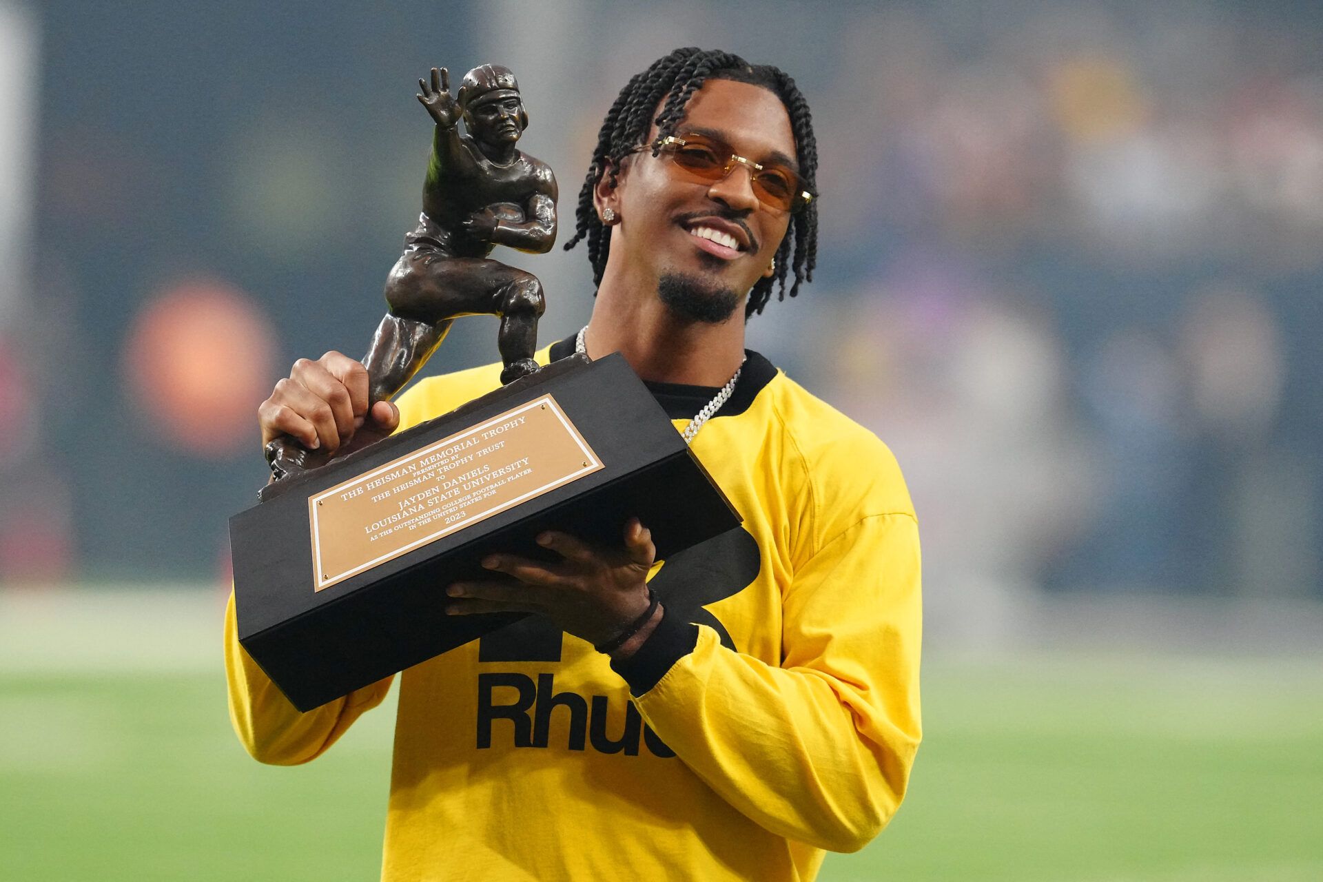Former LSU Tigers quarterback Jayden Daniels poses with the 2023 Heisman Memorial Trophy during a game between the Tigers and the Southern California Trojans at Allegiant Stadium.