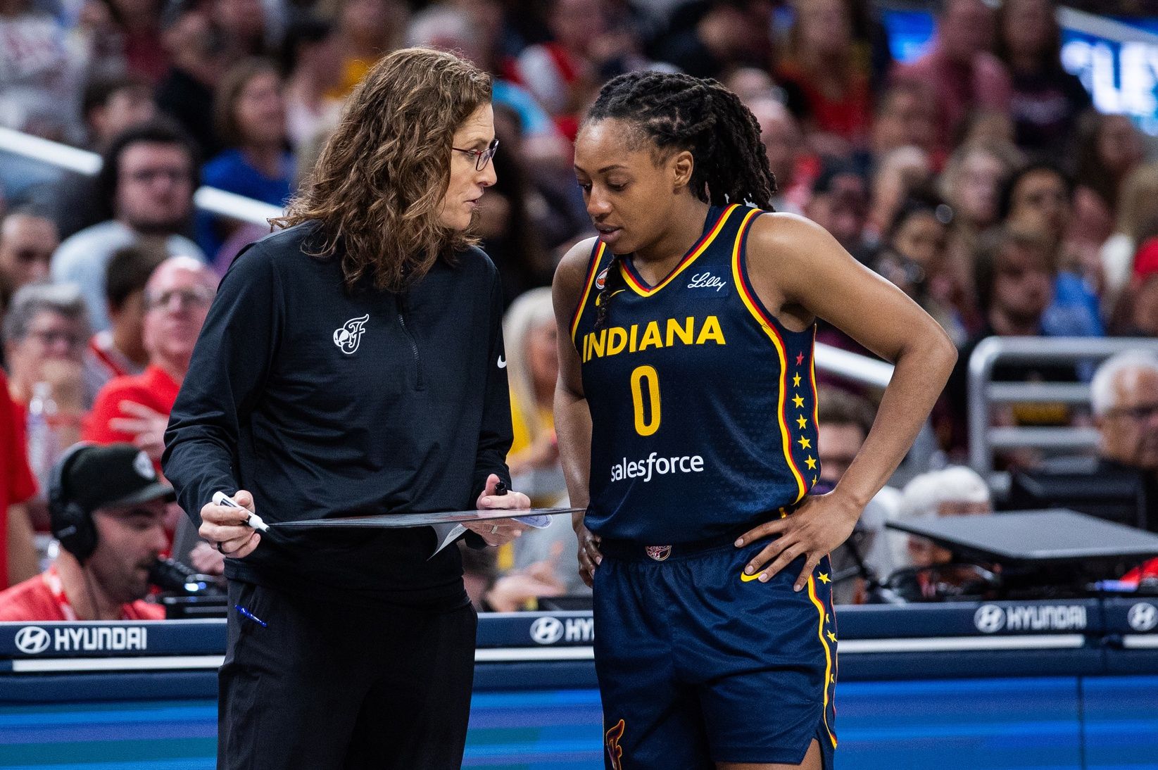 Indiana Fever head coach Stephanie White talks with guard Kelsey Mitchell (0) in the second half against the Los Angeles Sparks at Gainbridge Fieldhouse.