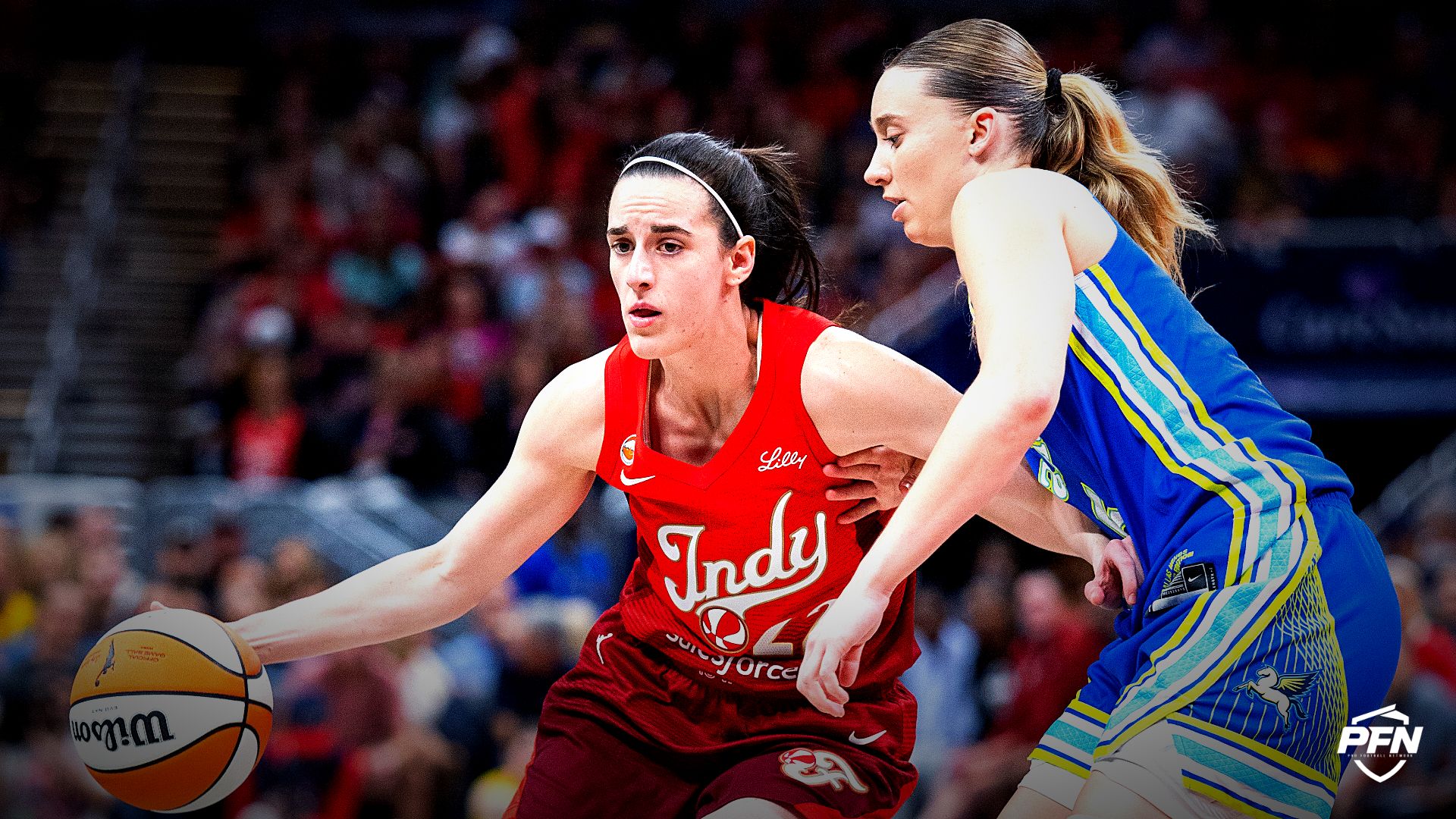 Indiana Fever guard Caitlin Clark (22) dribbles the ball while Dallas Wings guard Paige Bueckers (5) defends in the first half at Gainbridge Fieldhouse.