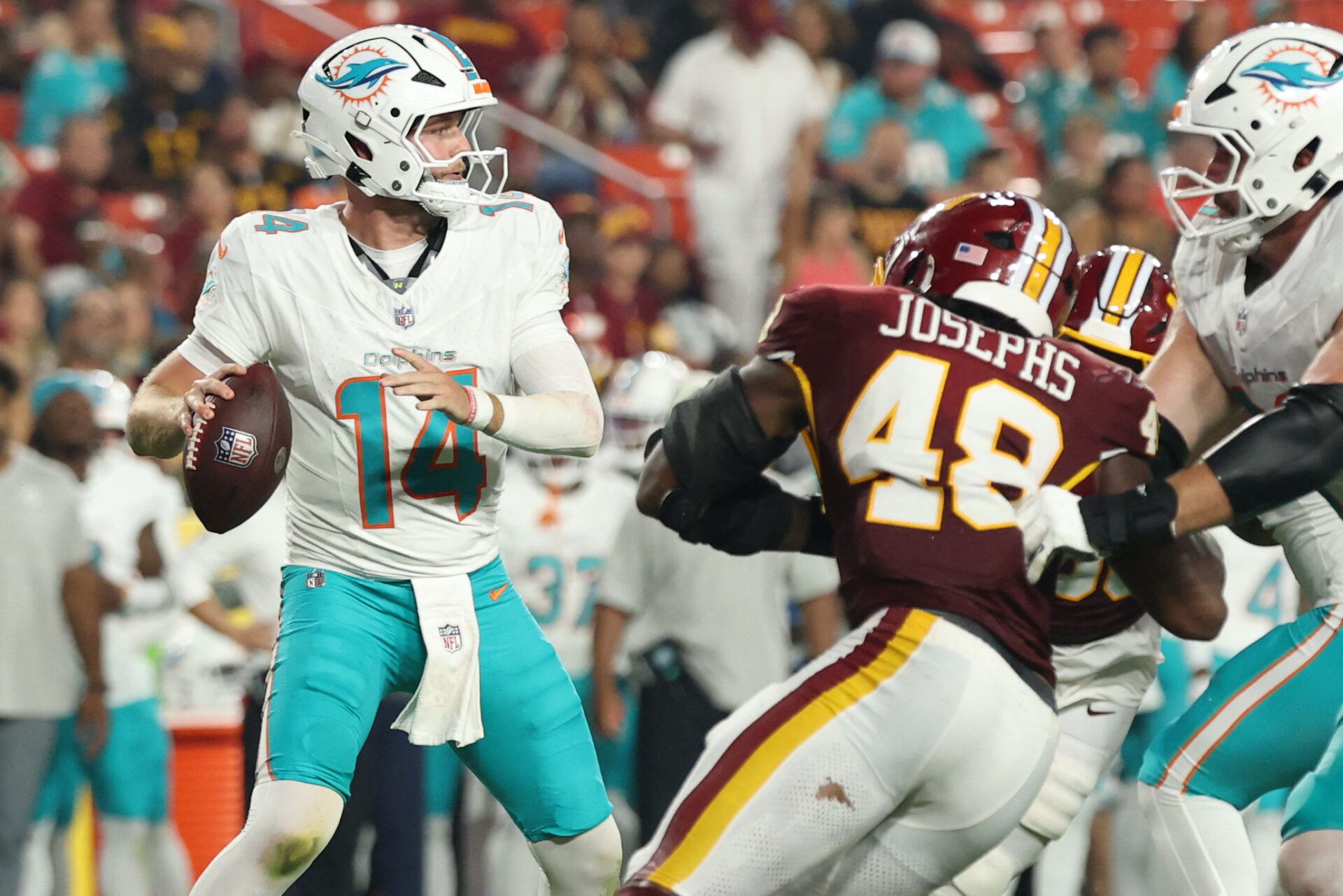 Miami Dolphins quarterback Quinn Ewers (14) passes the ball as Washington Commanders linebacker Joshua Josephs (48) rushes during the first half at Northwest Stadium.