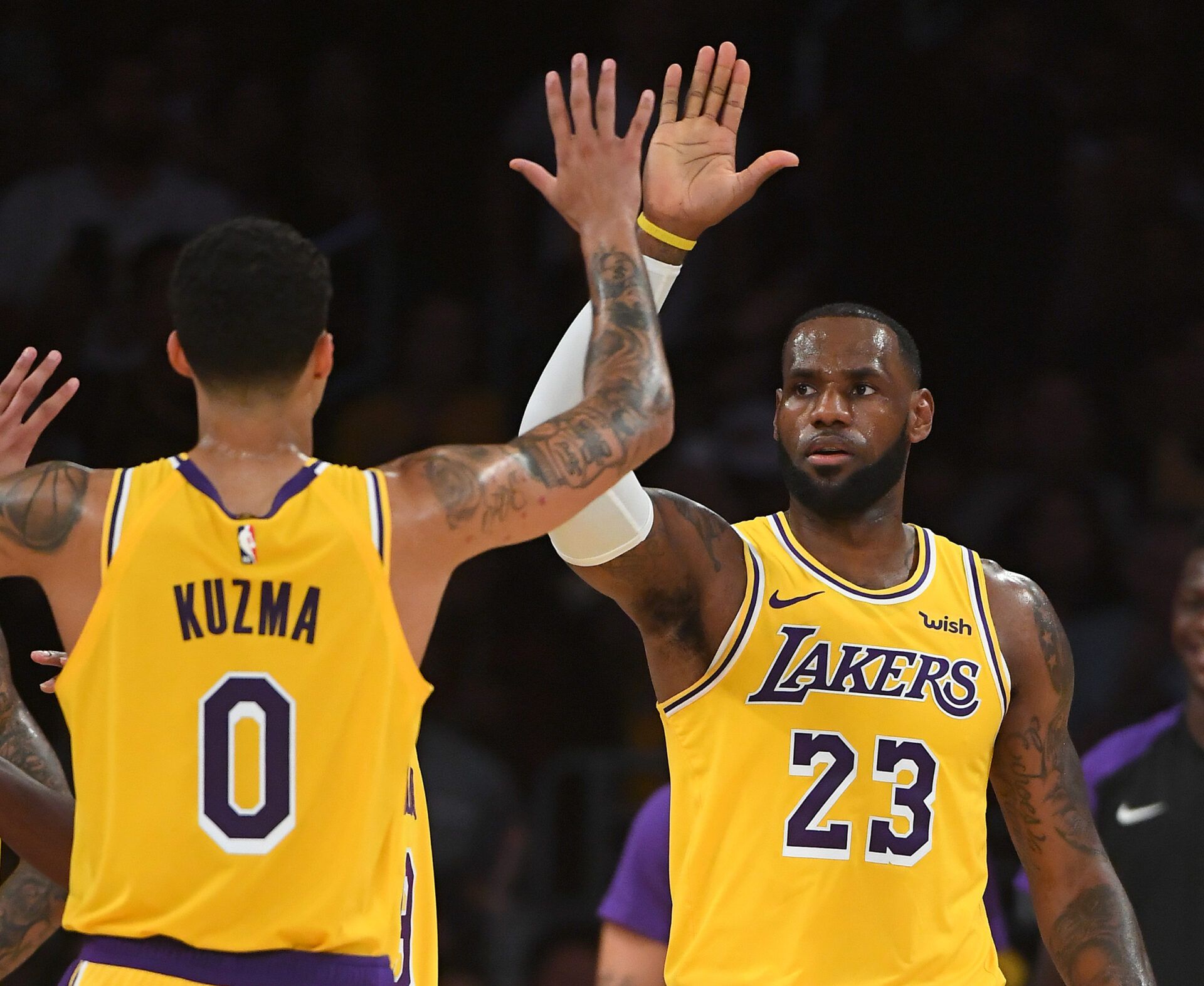Los Angeles Lakers forward LeBron James (23) and forward Kyle Kuzma (0) celebrate on the court in the first half of the game against the Denver Nuggets at Staples Center.