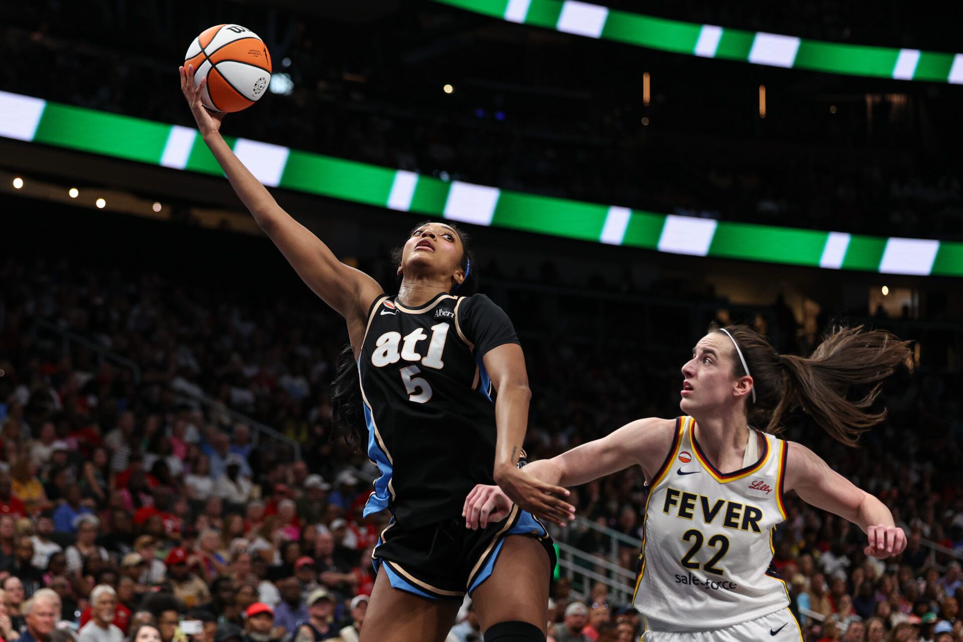 Atlanta Dream forward Angel Reese (5) shoots against Indiana Fever guard Caitlin Clark (22) during the third quarter at State Farm Arena.