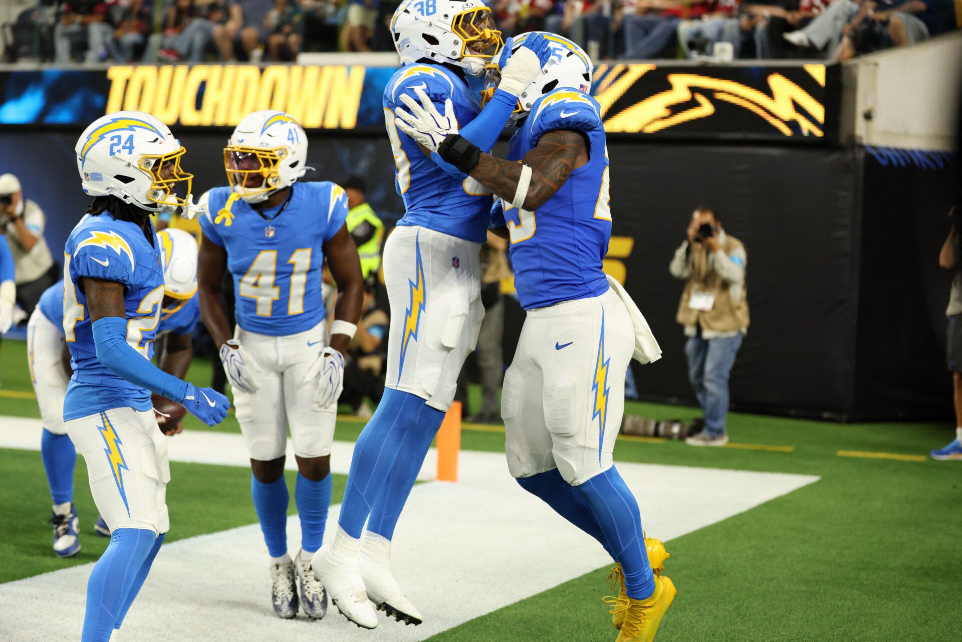 Los Angeles Chargers linebacker Junior Colson (25) celebrates with safety Devin Grant (38) after a pick six during the third quarter against the San Francisco 49ers at SoFi Stadium.