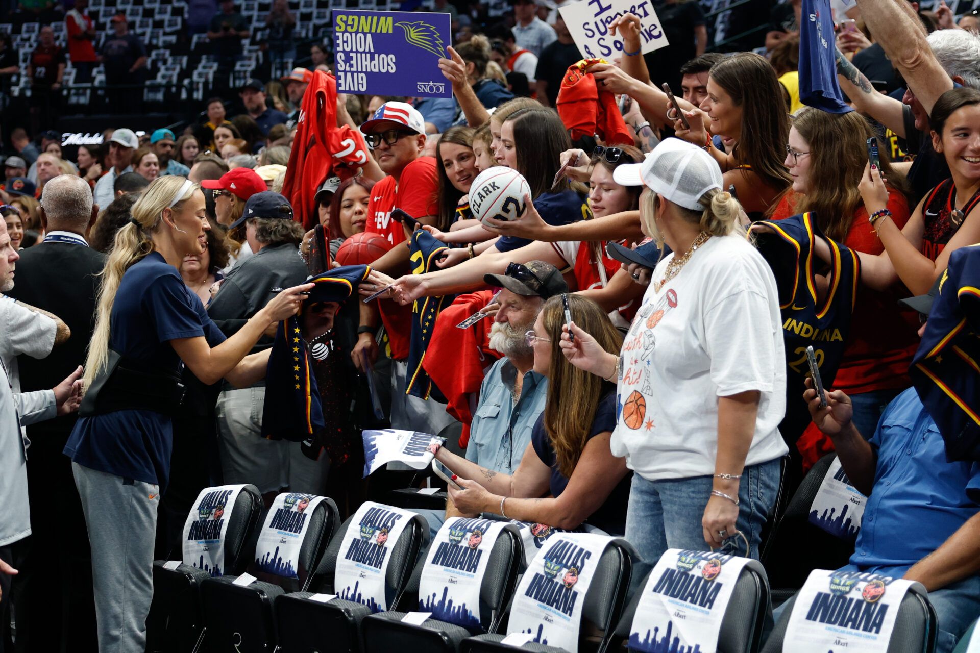 Indiana Fever guard Sophie Cunningham (8) autographs jerseys for fans before the game against the Dallas Wings at American Airlines Center.