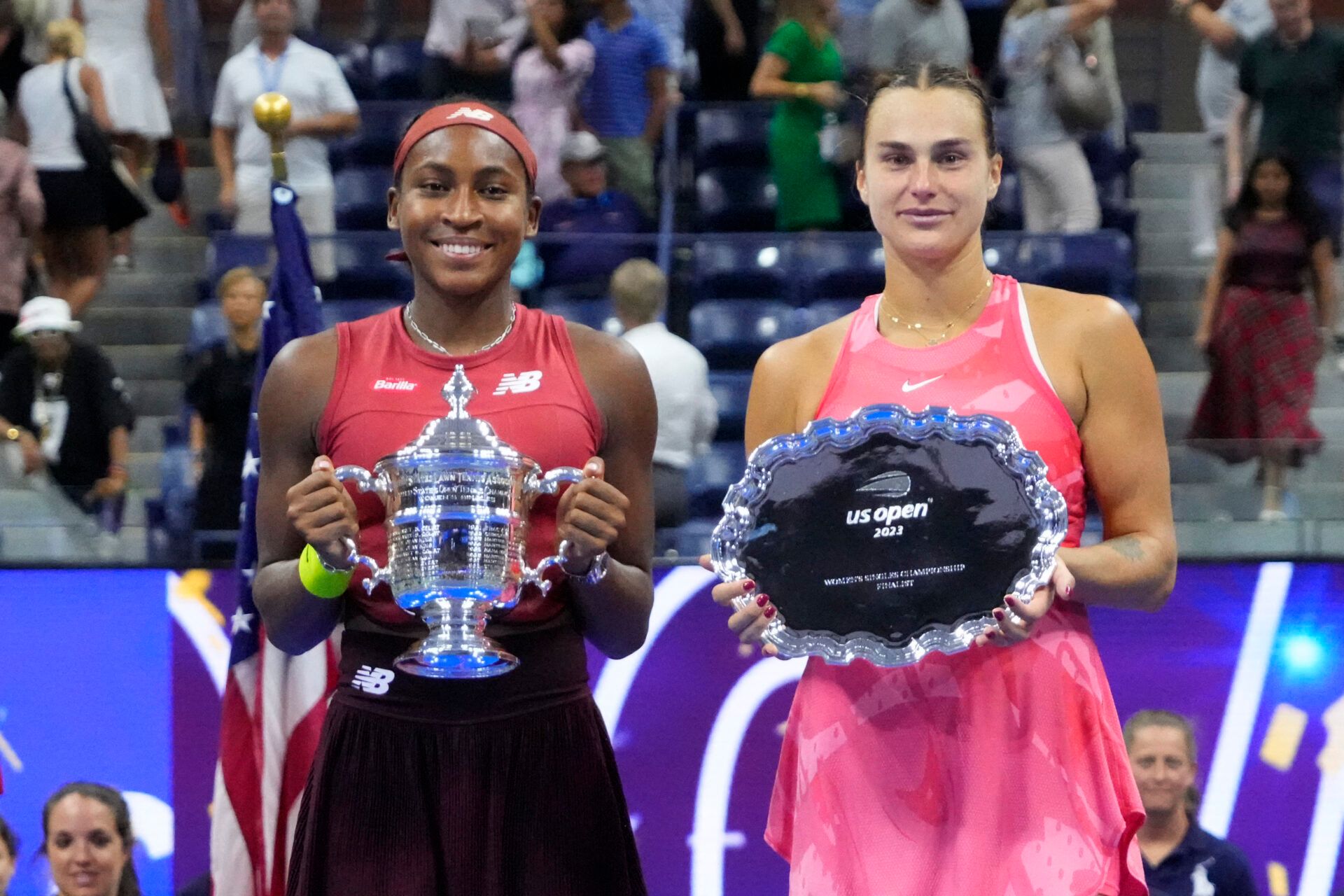 (L-R) Coco Gauff of the United States and Aryna Sabalenka celebrate with the championship and finalist trophies, respectively, after their match in the women's singles finalon day thirteen of the 2023 U.S. Open tennis tournament at USTA Billie Jean King Tennis Center.