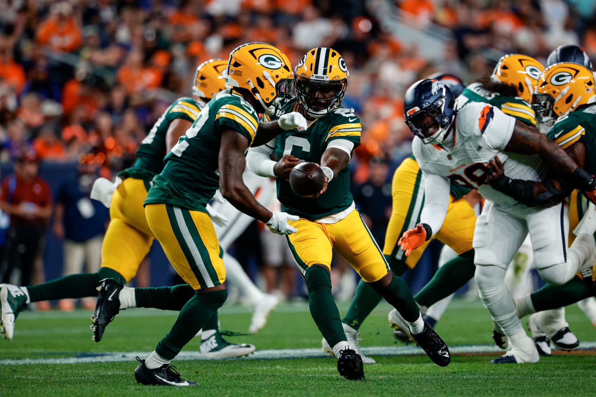 Green Bay Packers quarterback Tyrod Taylor (6) hands the ball off to running back Pierre Strong Jr. (22) in the second quarter against the Denver Broncos at Empower Field at Mile High.