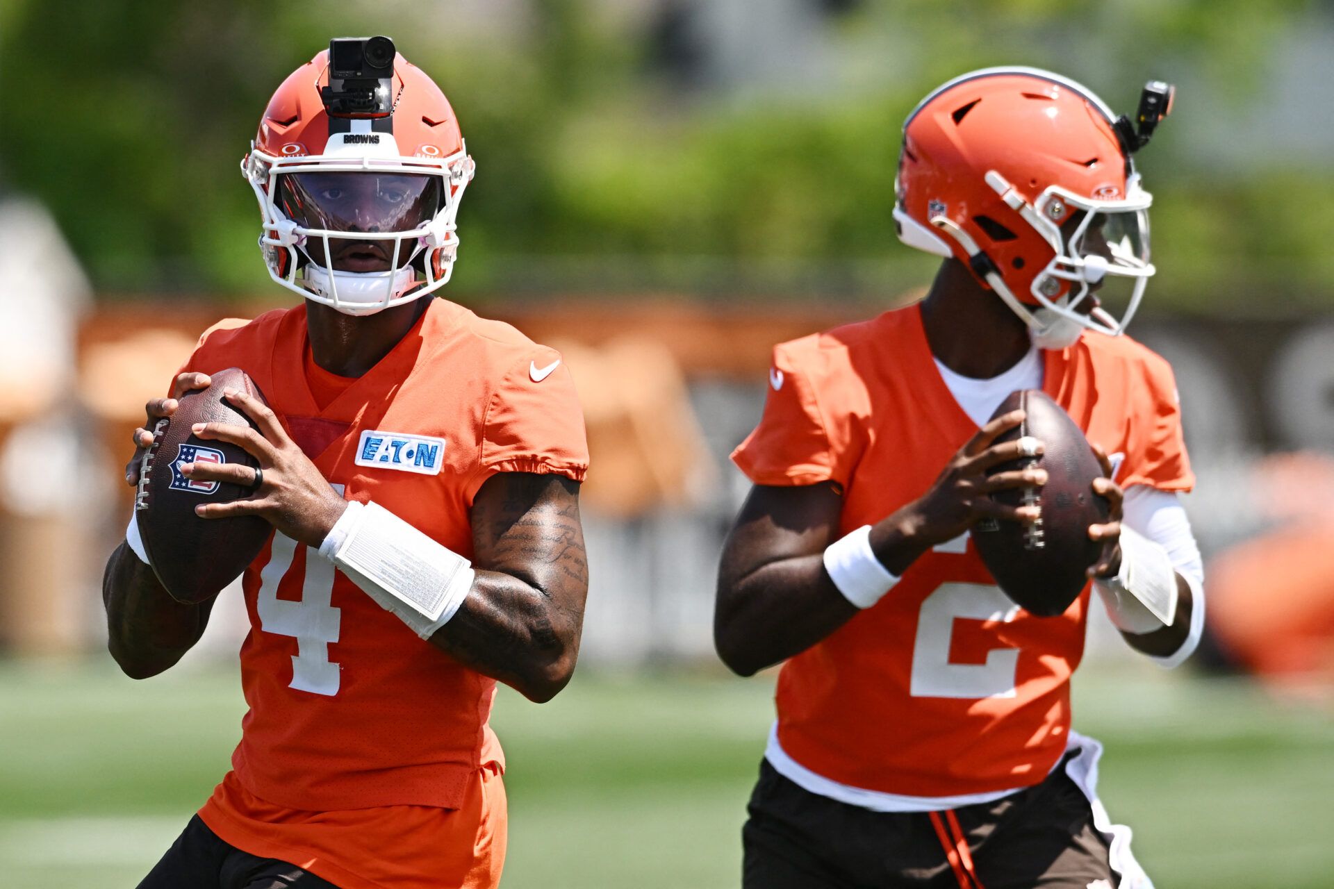 Cleveland Browns quarterback Shedeur Sanders (2) and quarterback Deshaun Watson (4) drop back to pass during training camp at CrossCountry Mortgage Campus.