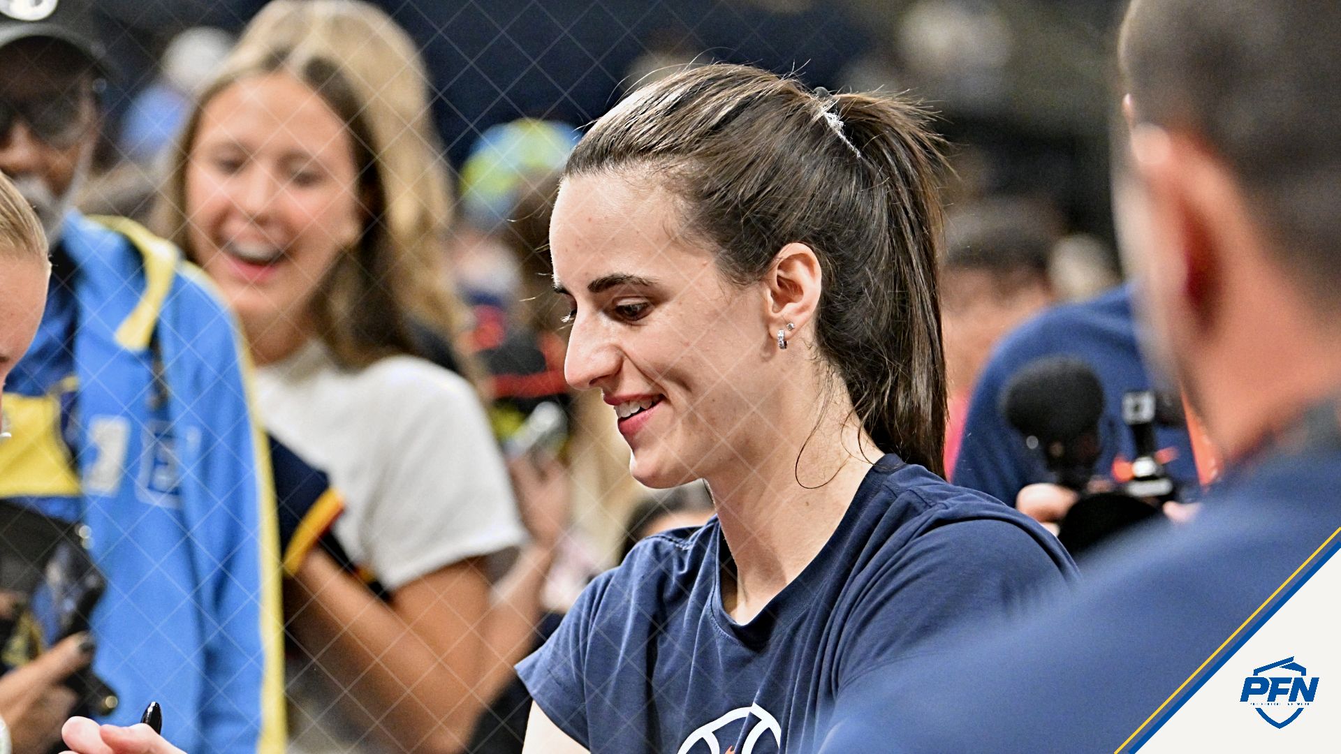 Indiana Fever guard Caitlin Clark (22) signs autographs for fans prior to a game against the Chicago Sky at Wintrust Arena.