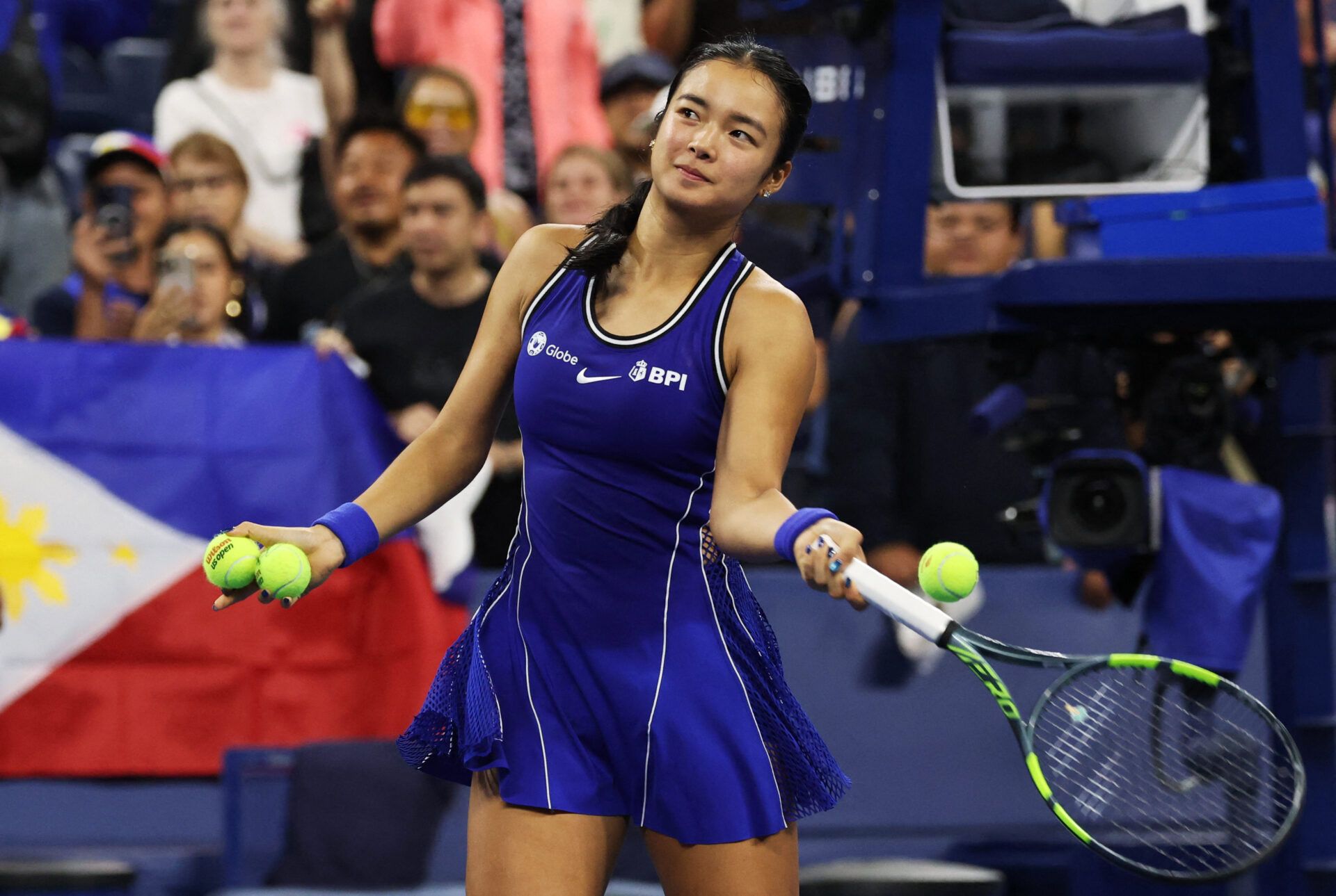 Philippines' Alexandra Eala hits autographed tennis balls into the stands after winning her first round match against Mary Stoiana of the U.S.