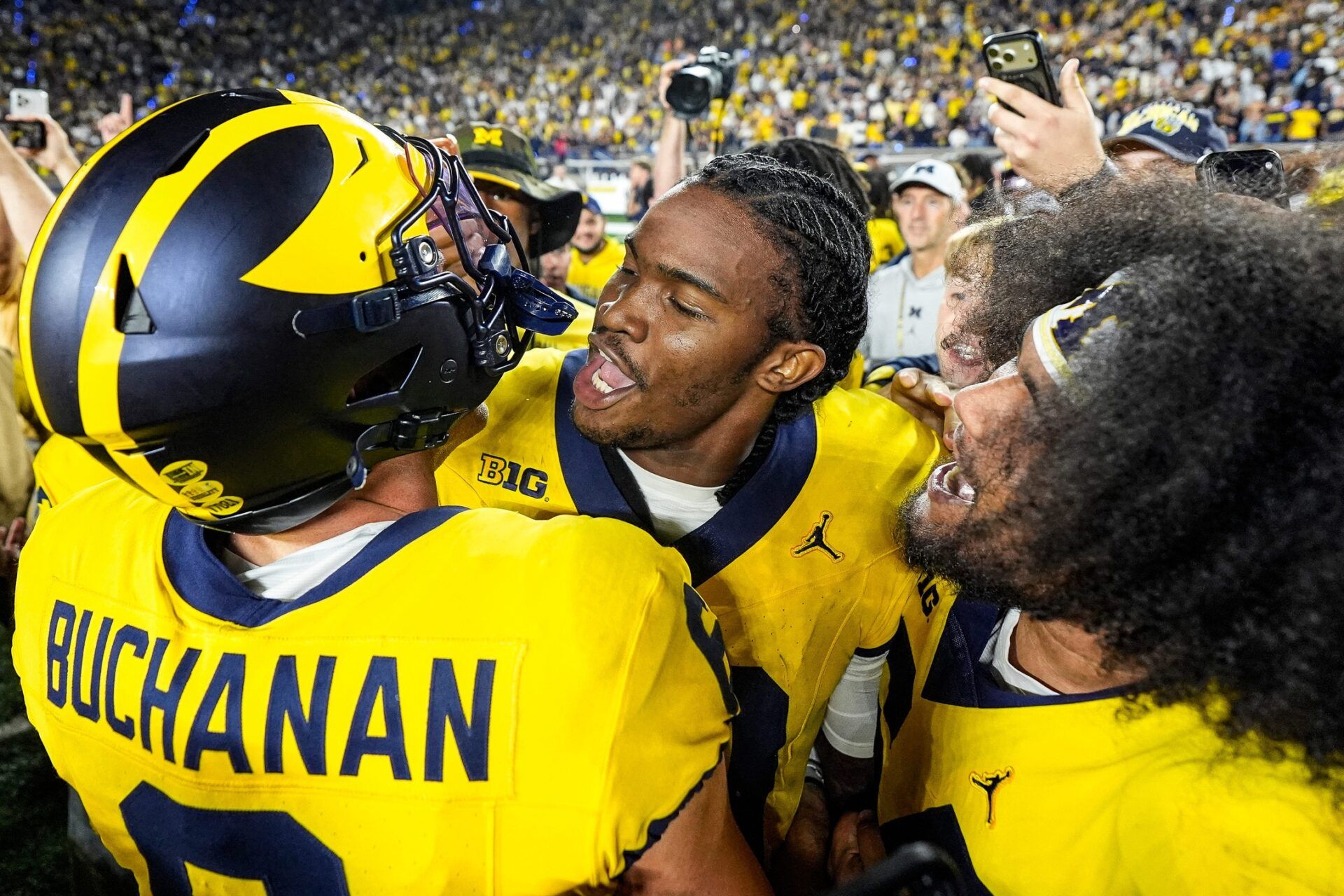 Michigan quarterback Bryce Underwood (19), center, hugs wide receiver JJ Buchanan (6), left, and defensive tackle Deyvid Palepale (54) after 13-12 win over Western Michigan at Michigan Stadium in Ann Arbor on Saturday, Sept. 5, 2026.